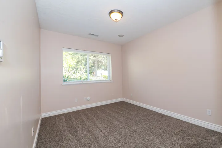 Room with neutral wall color and brown patterned carpeting