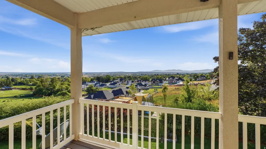 Covered balcony with white railing and distant mountain scenery