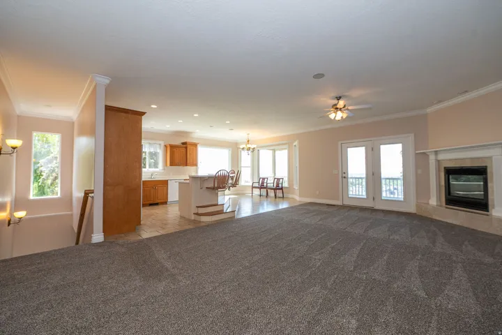 Open-concept living space featuring gray carpeting and a white trim package