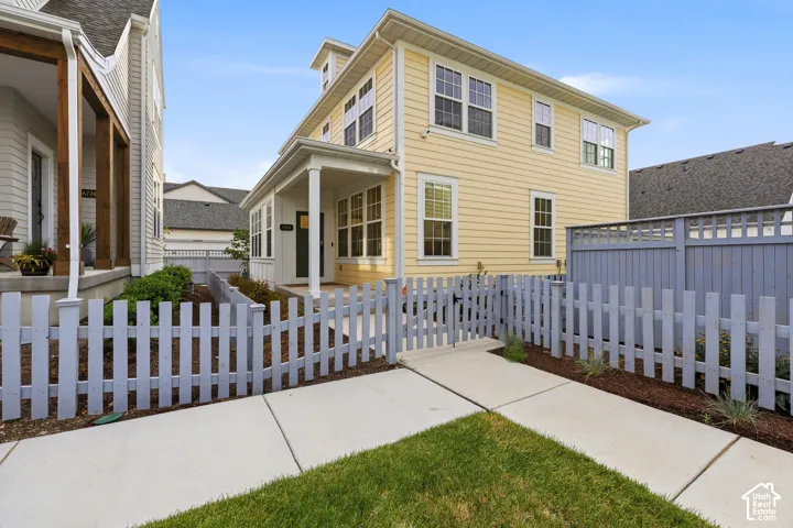 Two-story exterior with light yellow siding, white trim, and a covered porch