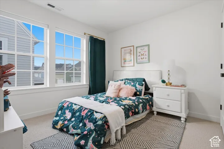 Room featuring neutral wall-to-wall carpeting and dual pane windows with grid detailing