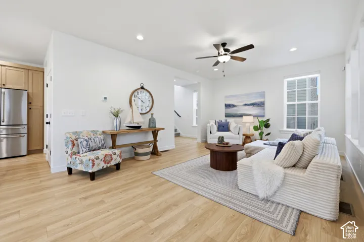 Open-concept living space featuring wood-finish flooring, recessed lighting, and a ceiling fan with light fixture