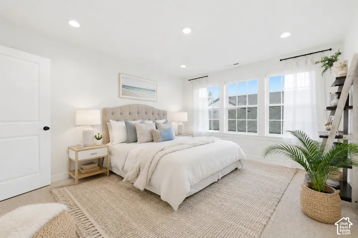 Bright room featuring three double-hung windows, recessed lighting, and a neutral color palette