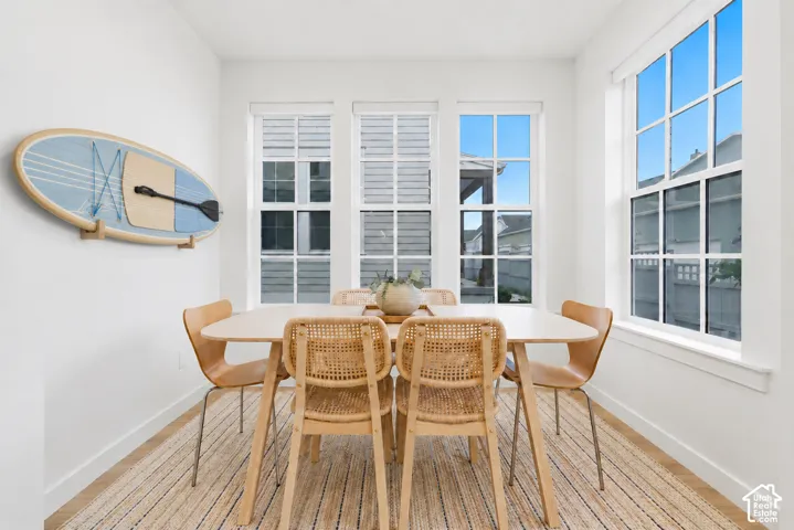Dining area featuring multiple windows, white baseboards, and light-toned flooring
