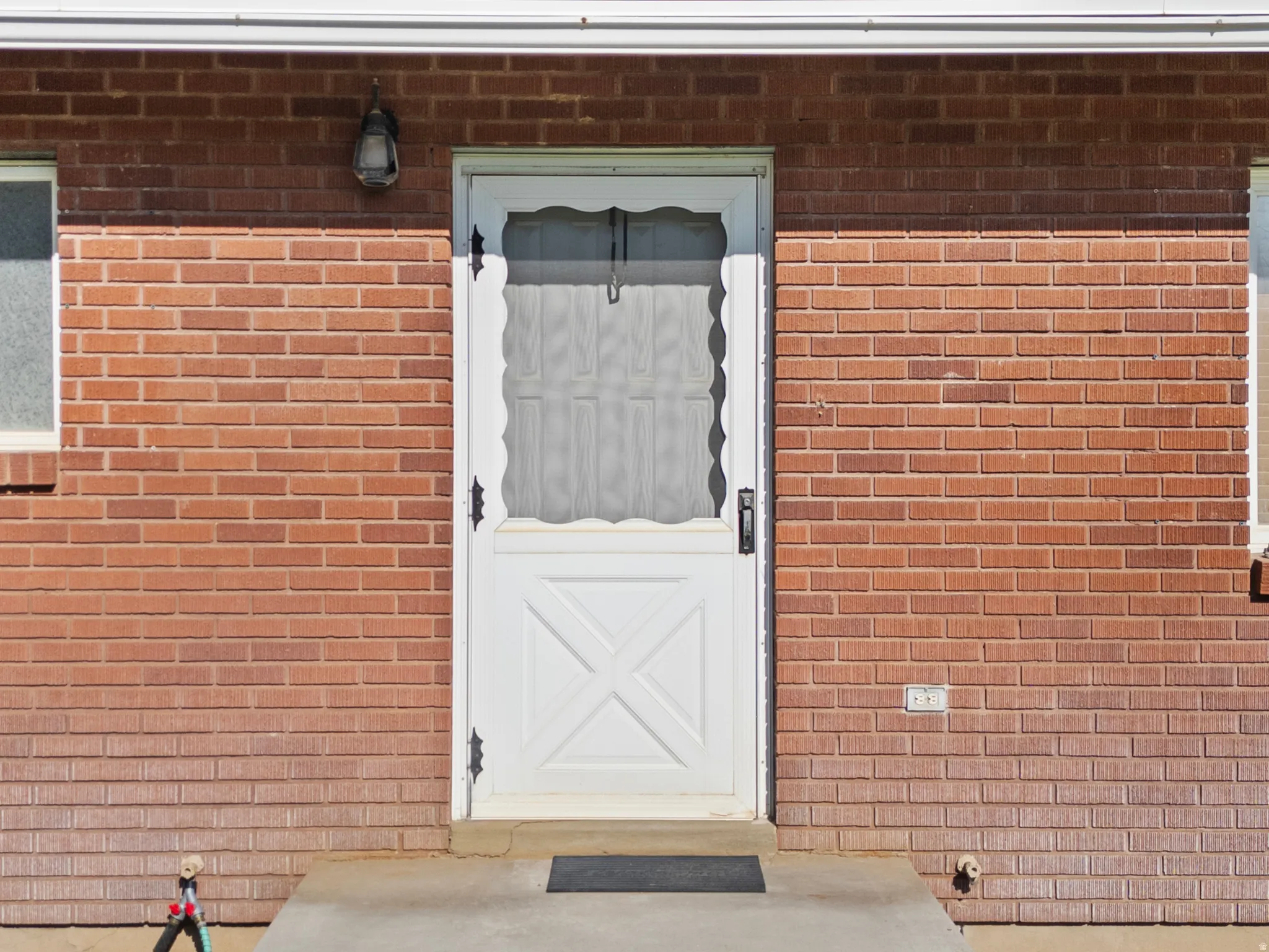 Brick facade with a white door featuring a decorative design