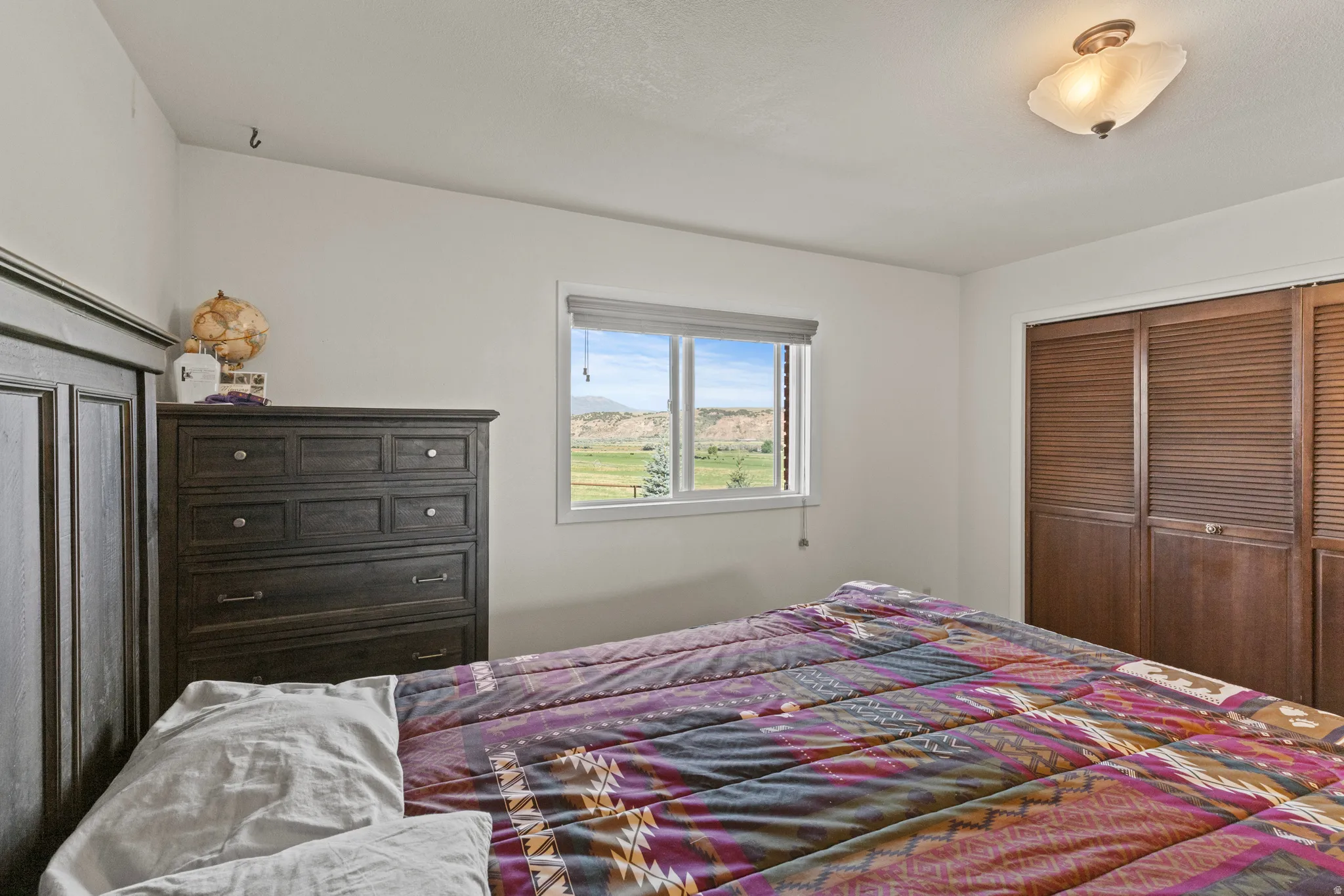 Window with expansive landscape scenery, recessed lighting, and wood-finish bifold closet doors