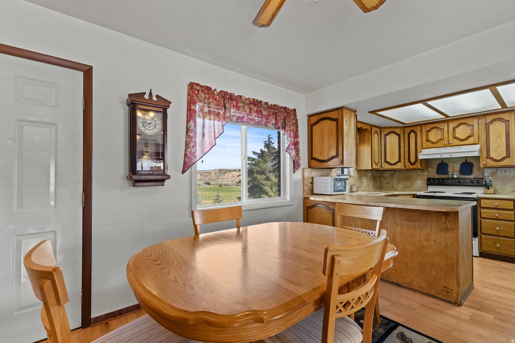 Eat-in kitchen featuring wood-finish flooring, ample cabinetry, a ceiling fan, and recessed lighting