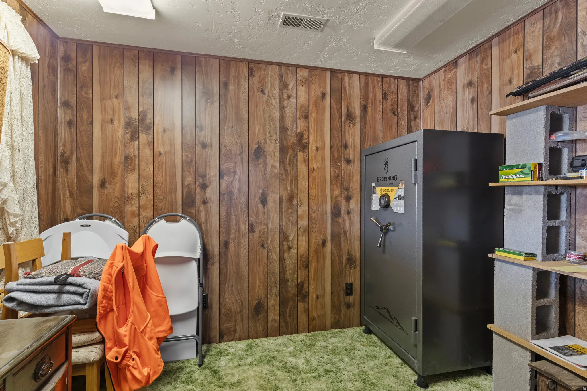 Room featuring wood-paneled walls, green carpet flooring.