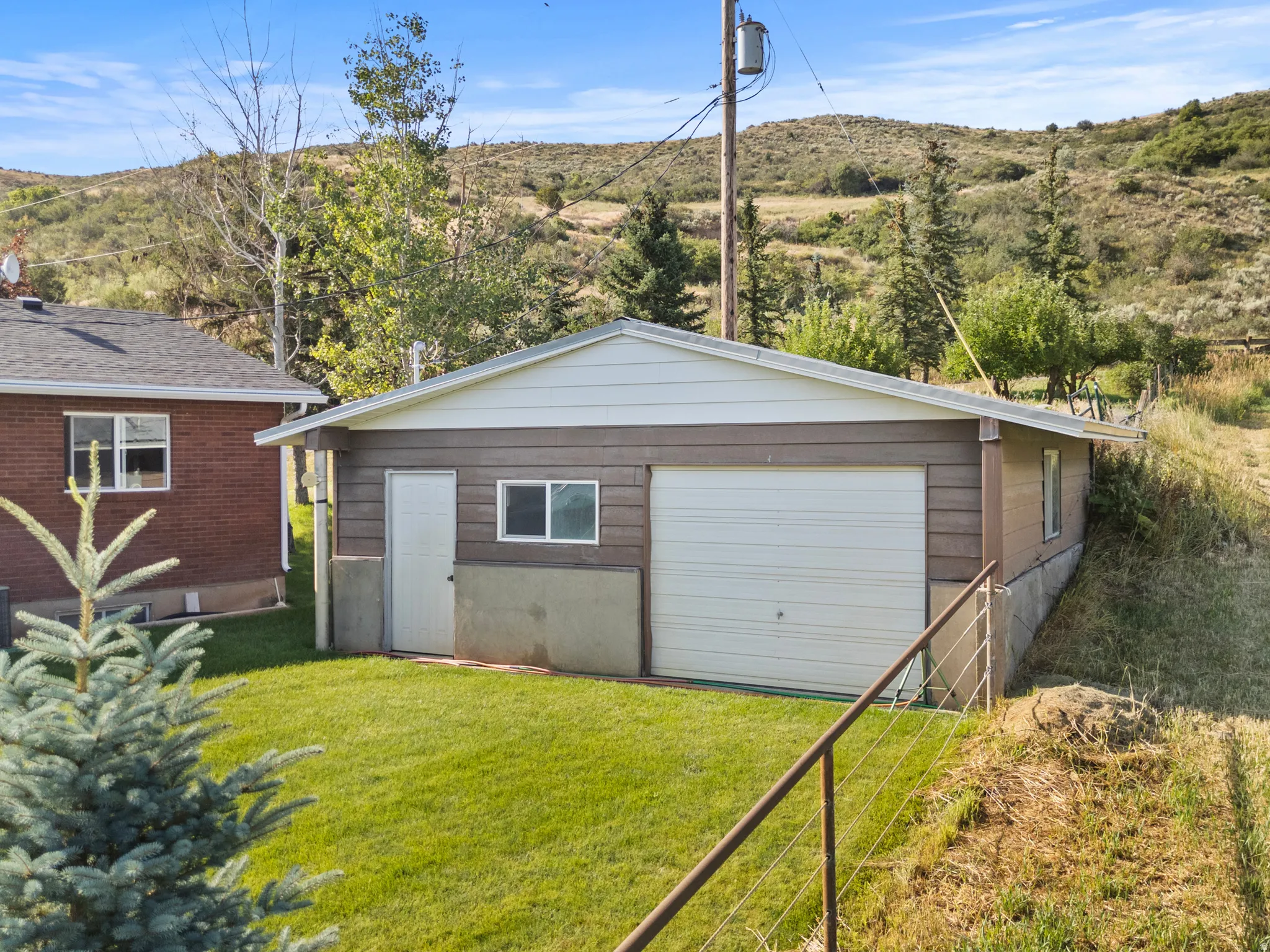 Detached 1 car garage with a single vehicle door and side entry, featuring horizontal siding and a white gable roof