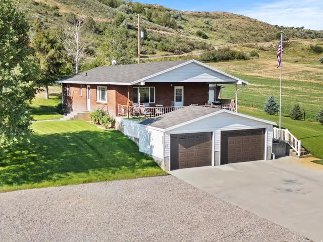 Brick exterior with a covered deck, two-car garage, and concrete driveway