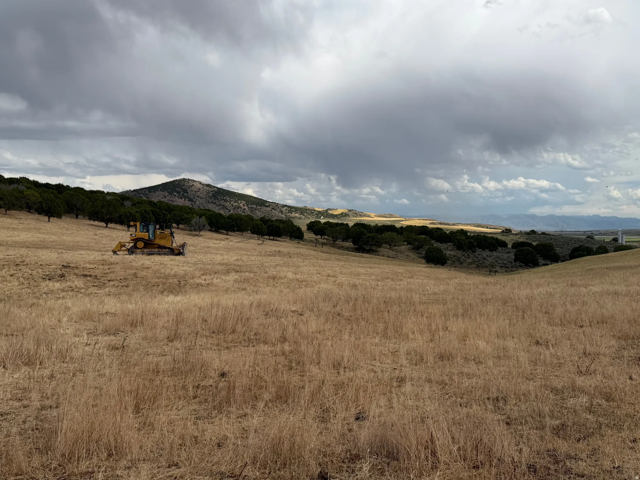 Expansive undeveloped land featuring rolling hills and distant mountain ranges