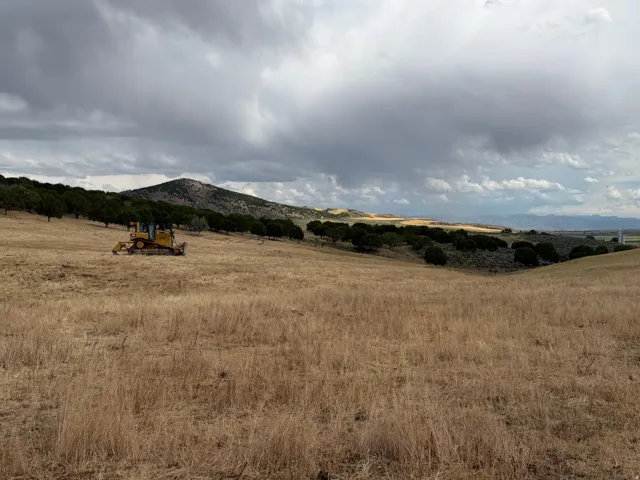 Expansive undeveloped land featuring rolling hills and distant mountain ranges