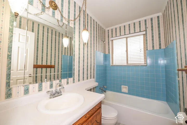 Bathroom featuring a white vanity with an integrated sink, chrome faucet, and wood-finish cabinetry