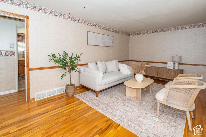 Natural wood-finish flooring complements the textured wall covering and wood trim