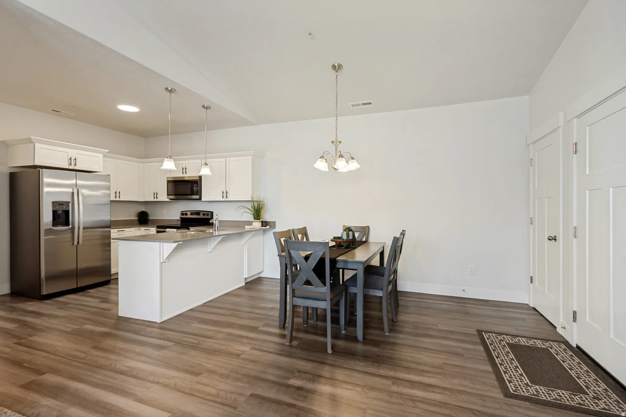 Open-concept kitchen and dining area featuring wood-finish flooring