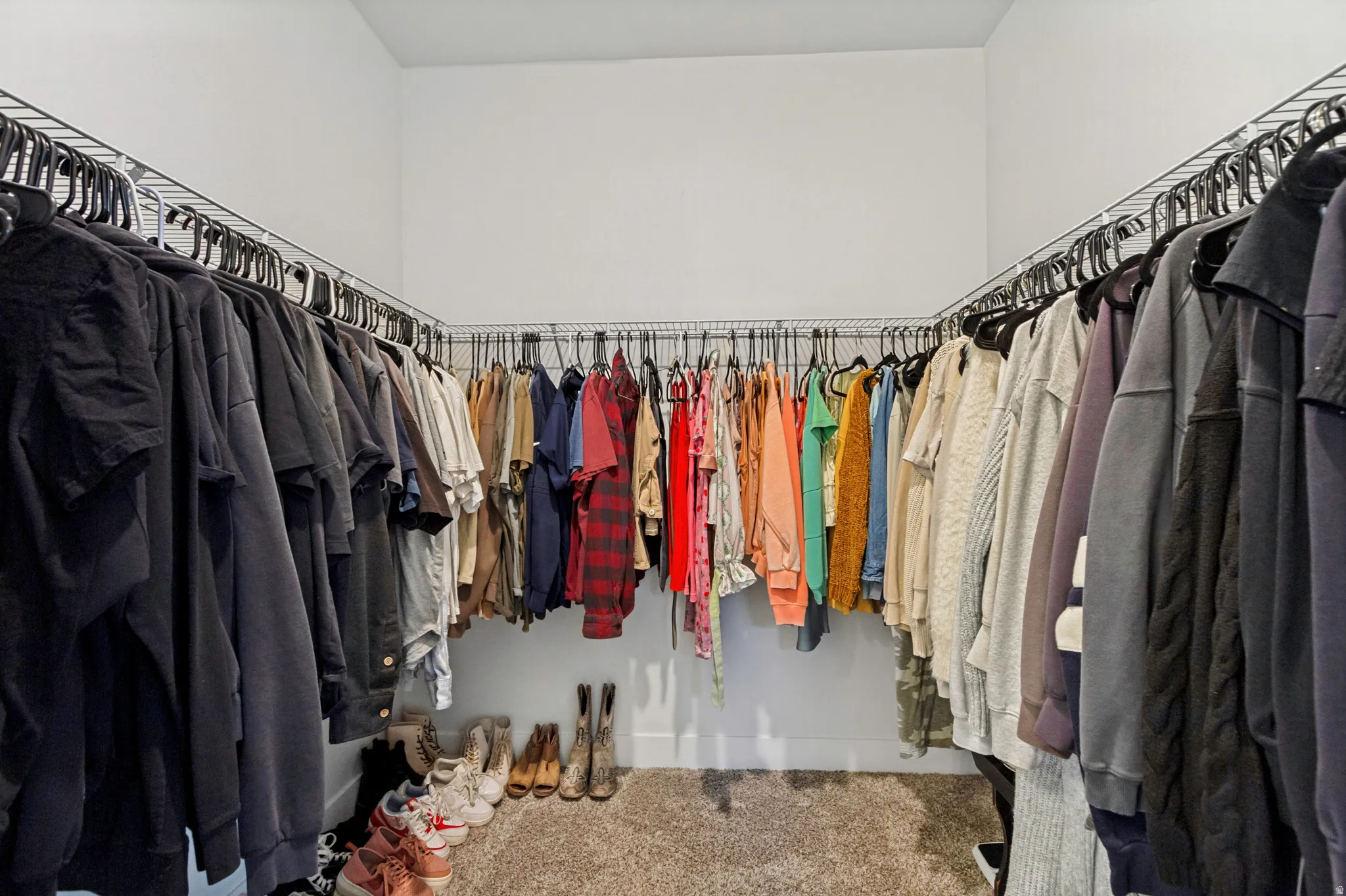 Walk-in closet featuring white walls, wire shelving, and carpeting