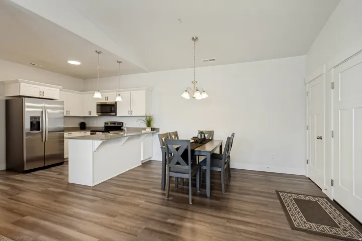 Open-concept kitchen and dining area featuring wood-finish flooring