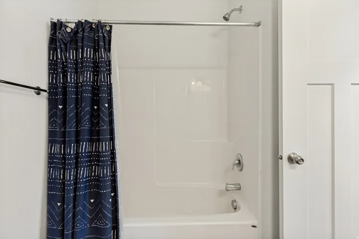 White tub and shower combination with chrome fixtures