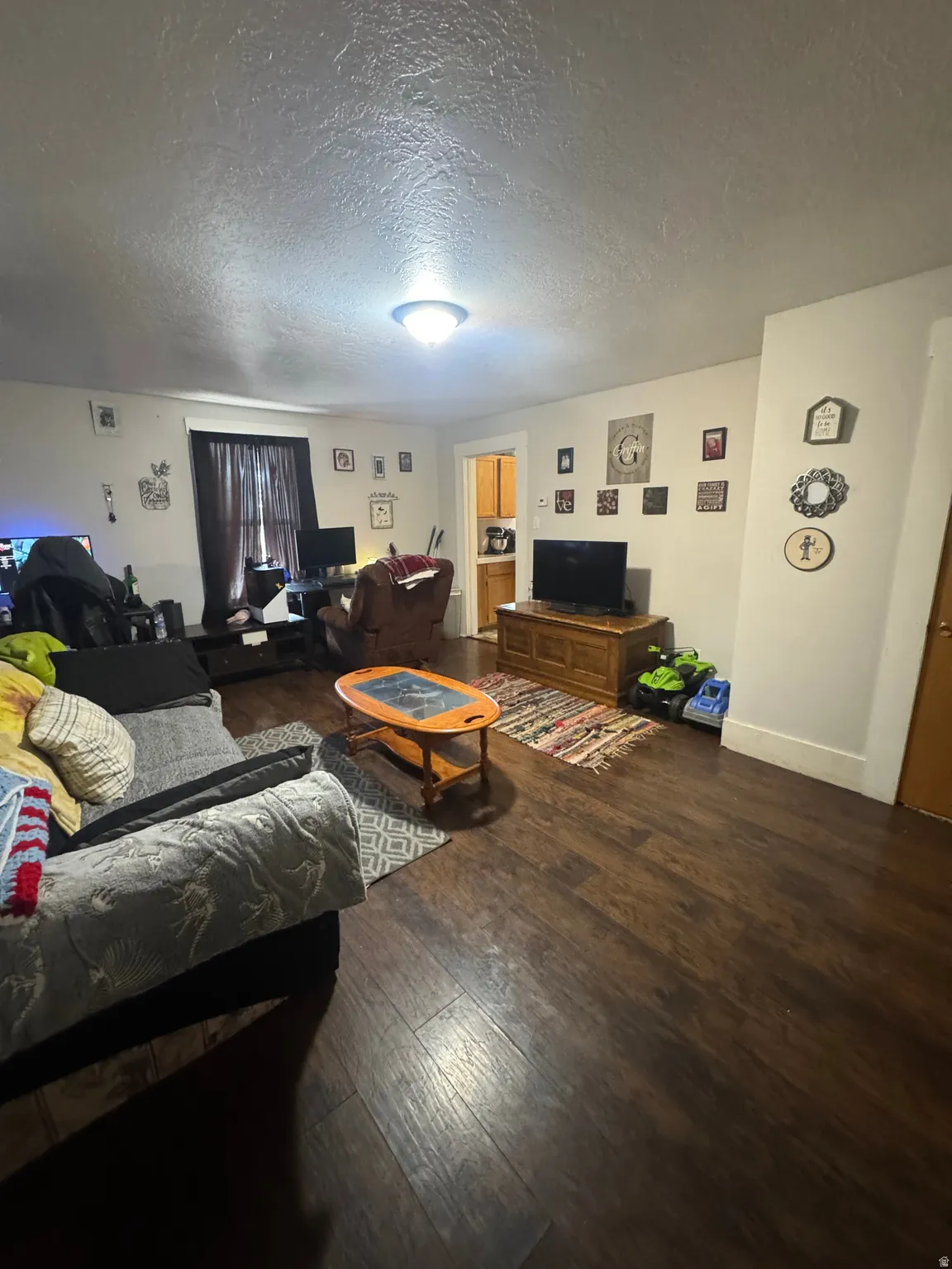 Spacious room featuring rich wood-finish flooring and light-toned walls