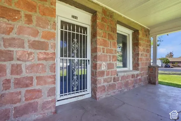 Stone exterior with a covered porch, security screen door, and window