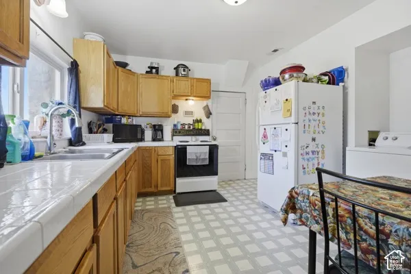 Kitchen featuring wood-finish cabinetry, tile countertops, and patterned flooring