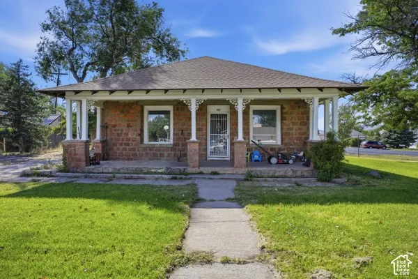 Stone exterior with a covered front porch featuring decorative white columns and a paved walkway