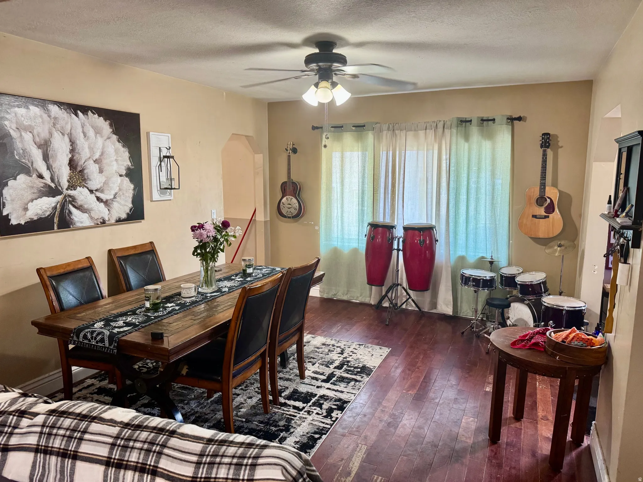 Spacious room featuring wood-finish flooring, a ceiling fan with integrated lighting, and neutral wall tones