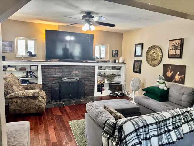 Living area featuring wood-finish flooring and a brick fireplace