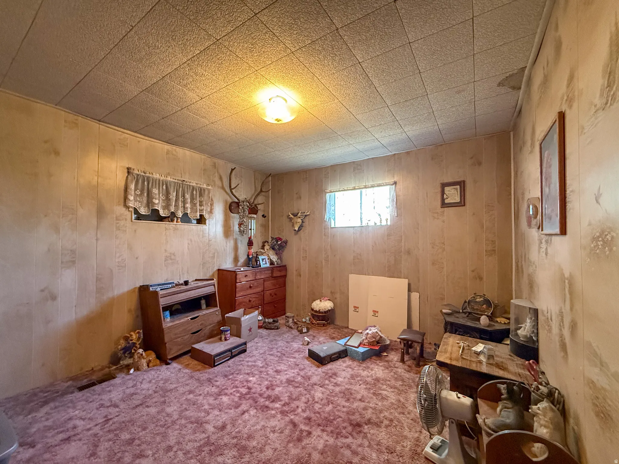 Room featuring acoustic panel ceiling tiles and wood-finish wall paneling
