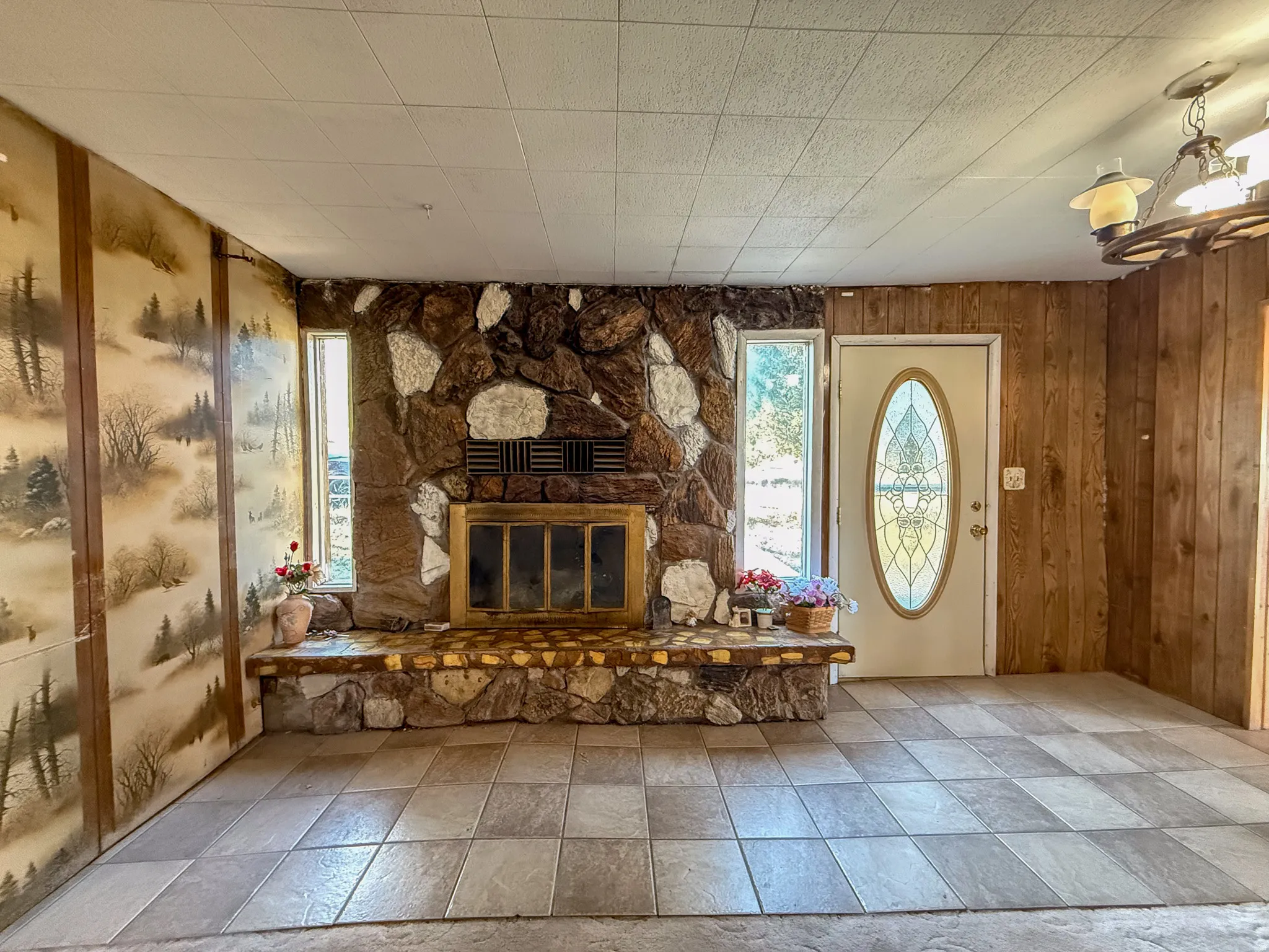 Stone-clad fireplace with a raised hearth, flanked by two vertical windows