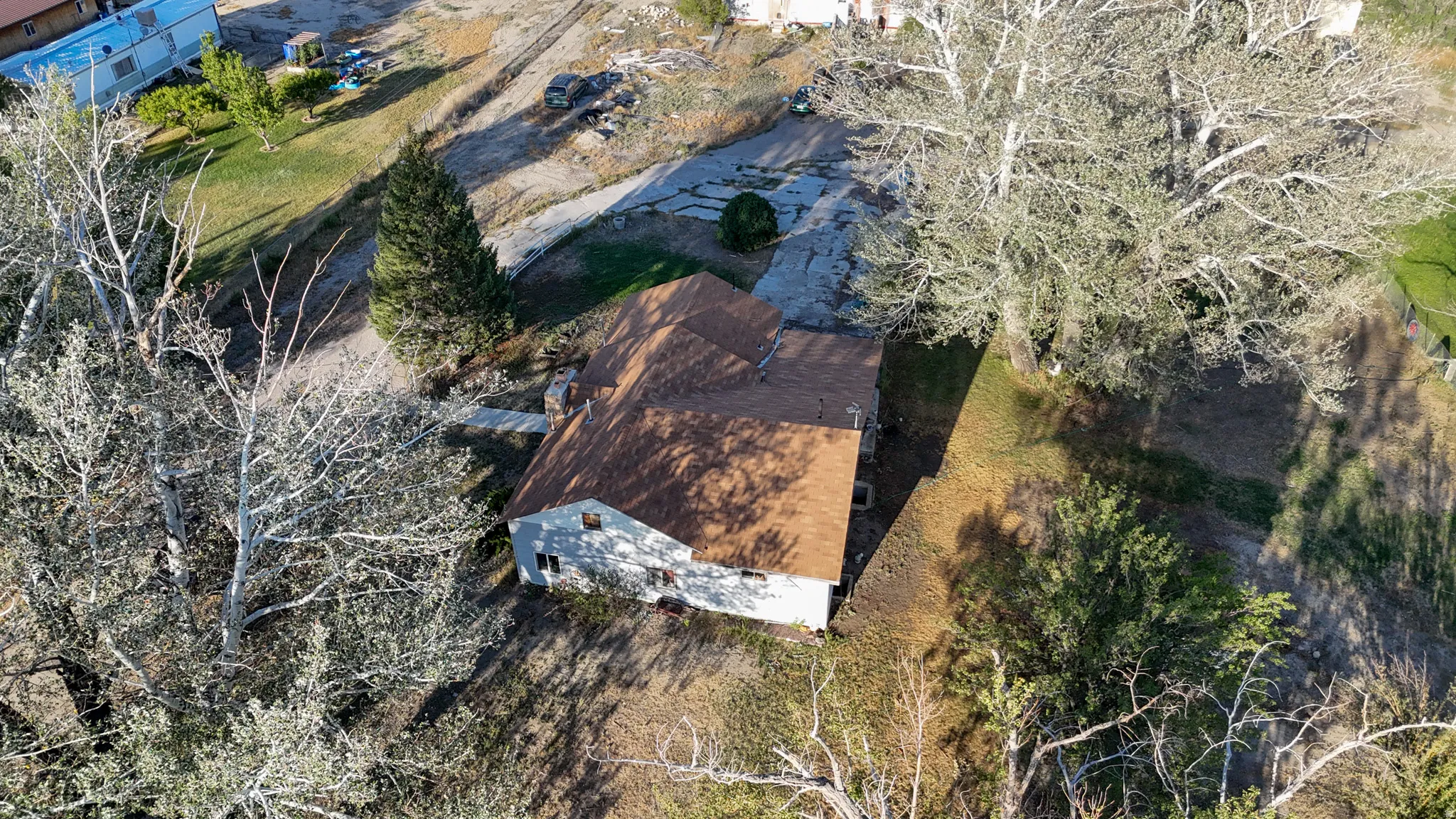 Single-story residence with a brown shingle roof, situated on a sloped lot