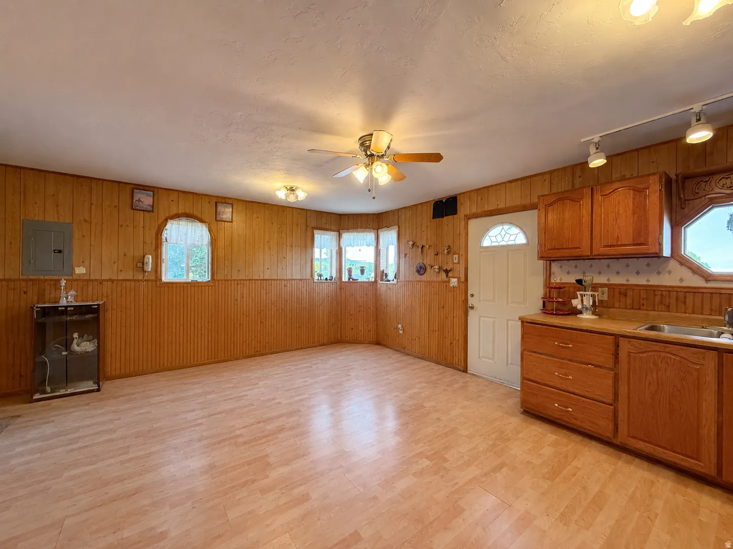 Wood-finish flooring with wood paneling walls and cabinetry