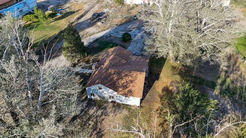 Single-story residence with a brown shingle roof, situated on a sloped lot