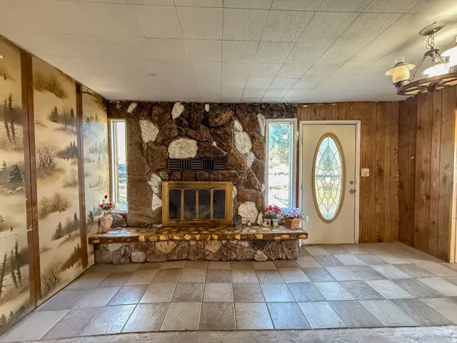 Stone-clad fireplace with a raised hearth, flanked by two vertical windows
