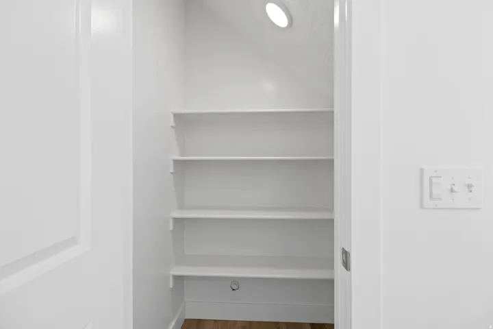 White built-in shelving with recessed ceiling lighting