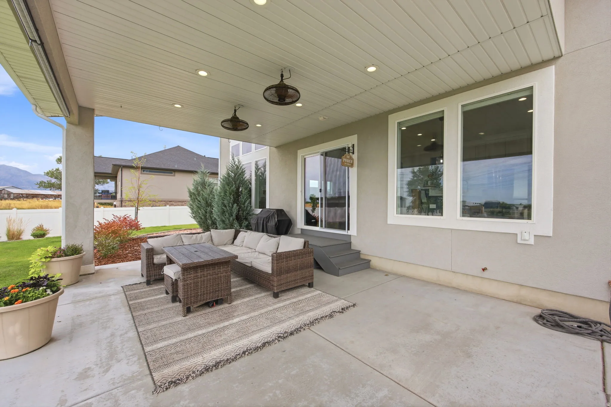 Covered patio featuring recessed lighting, two ceiling fans, and a sliding glass door
