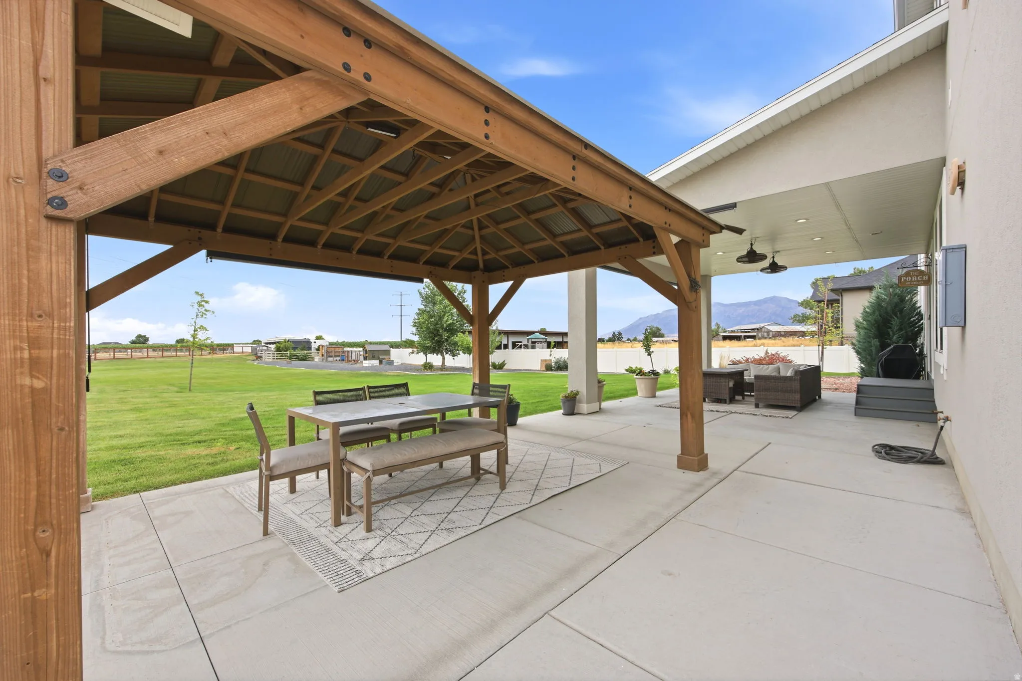 Spacious concrete patio with an attached wood pergola, offering ample outdoor living space