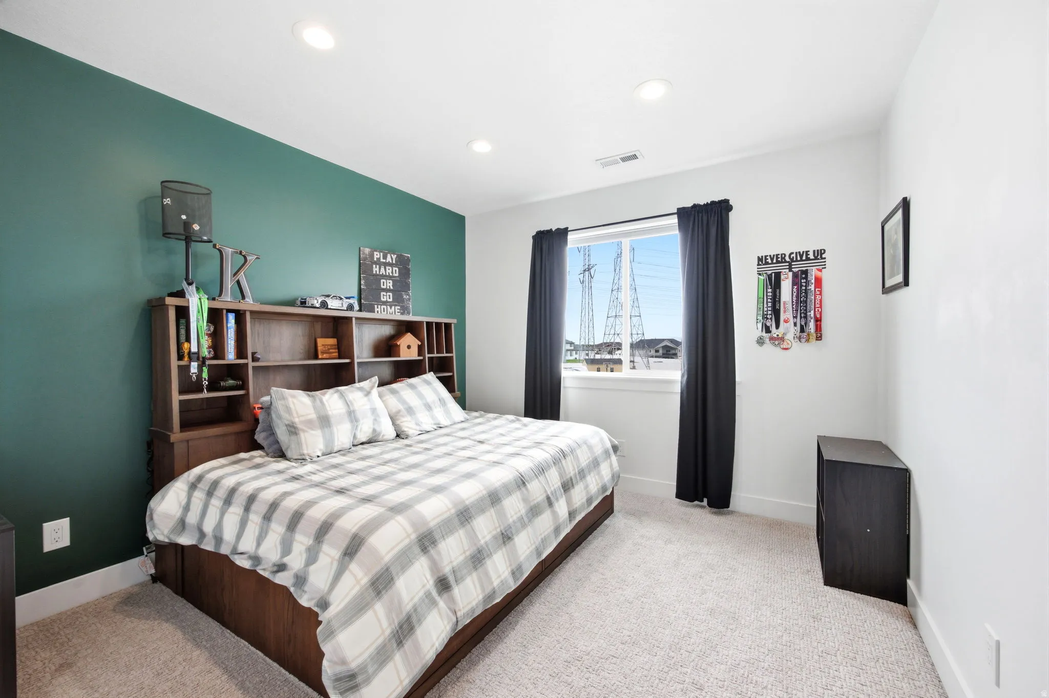 Bedroom featuring a prominent accent wall in a deep green hue