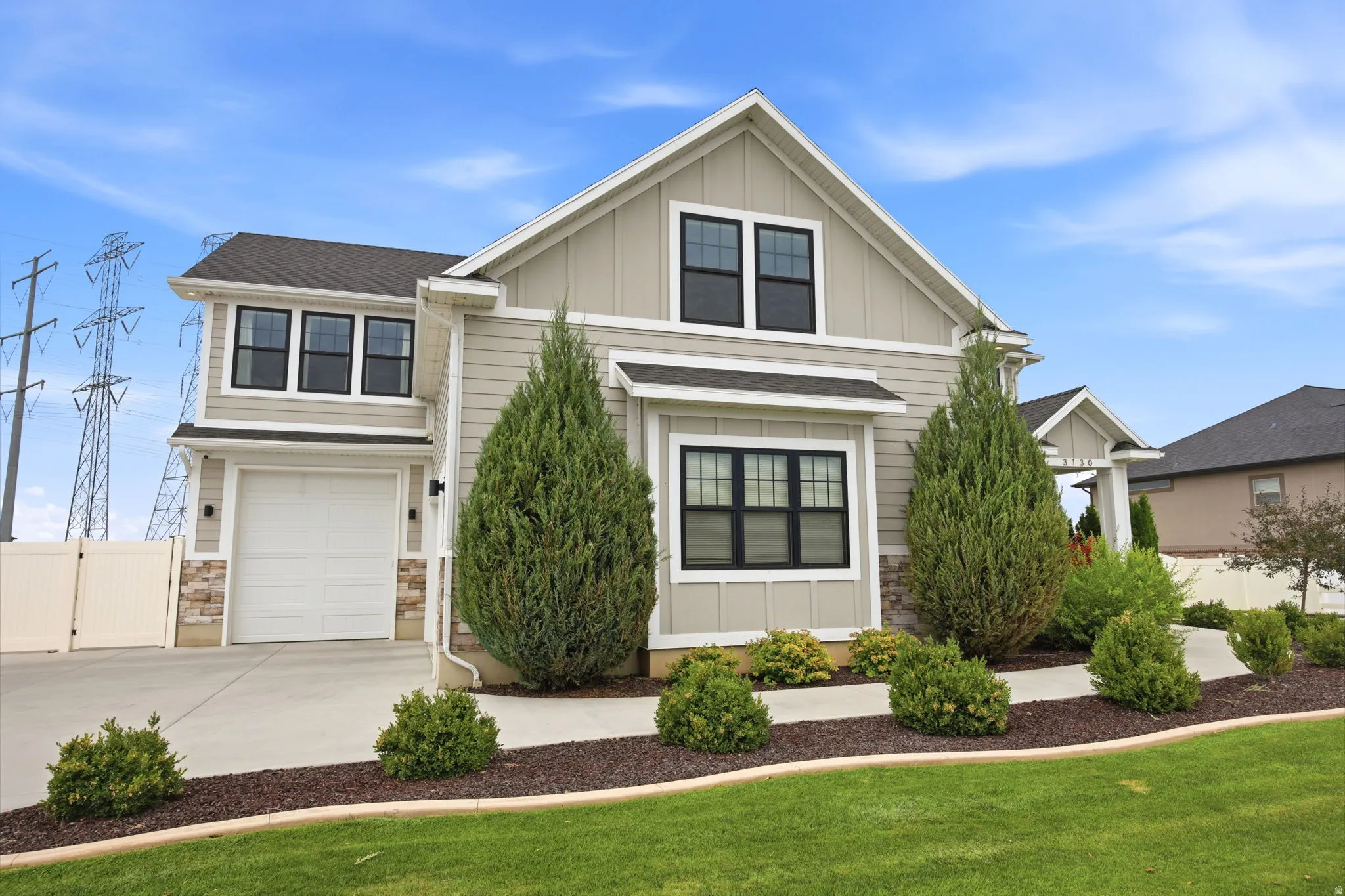 Two-story residence with light gray siding and dark trim windows