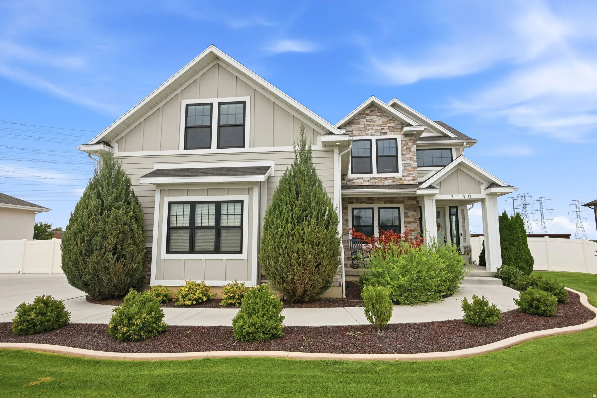 Two-story home with light-colored horizontal siding and stone accents