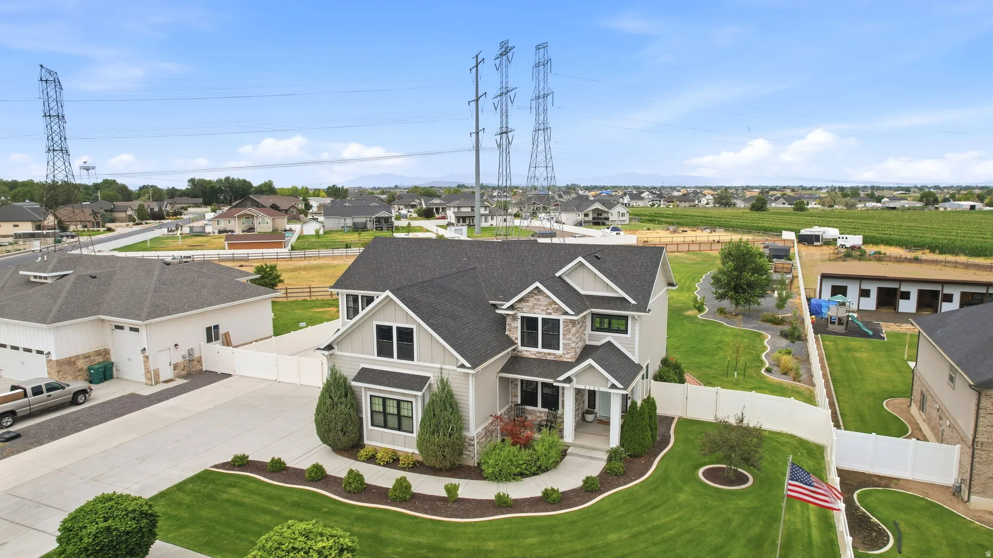 Two-story residence featuring a stone and siding exterior, multi-gabled roofline, front porch, and mature landscaping