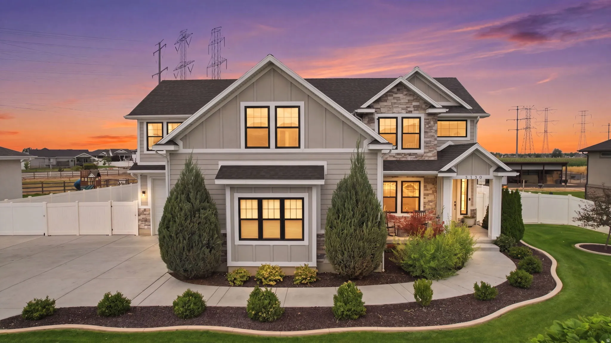 Two-story residence featuring a combination of siding and stone veneer, dark-framed windows, a concrete driveway, an arched walkway, and a manicured lawn
