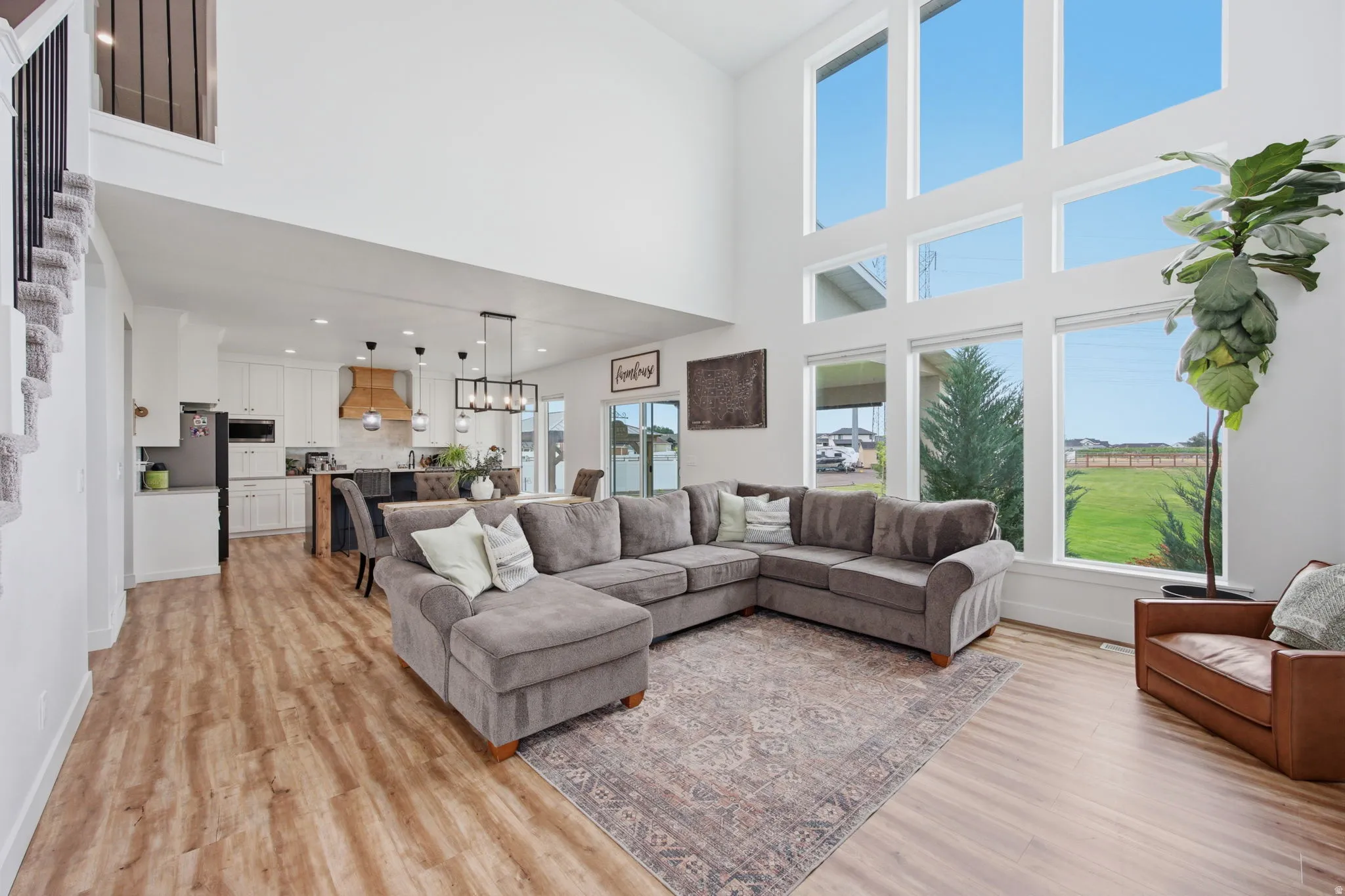 Two-story living area with high ceilings, featuring a bank of six large windows