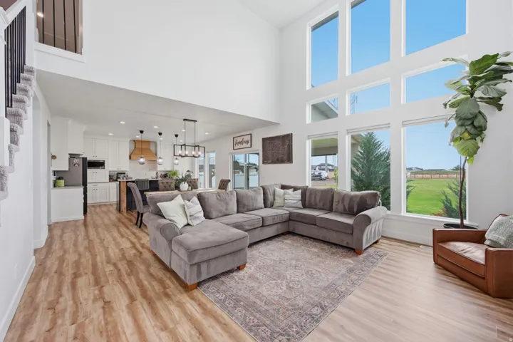 Two-story living area with high ceilings, featuring a bank of six large windows
