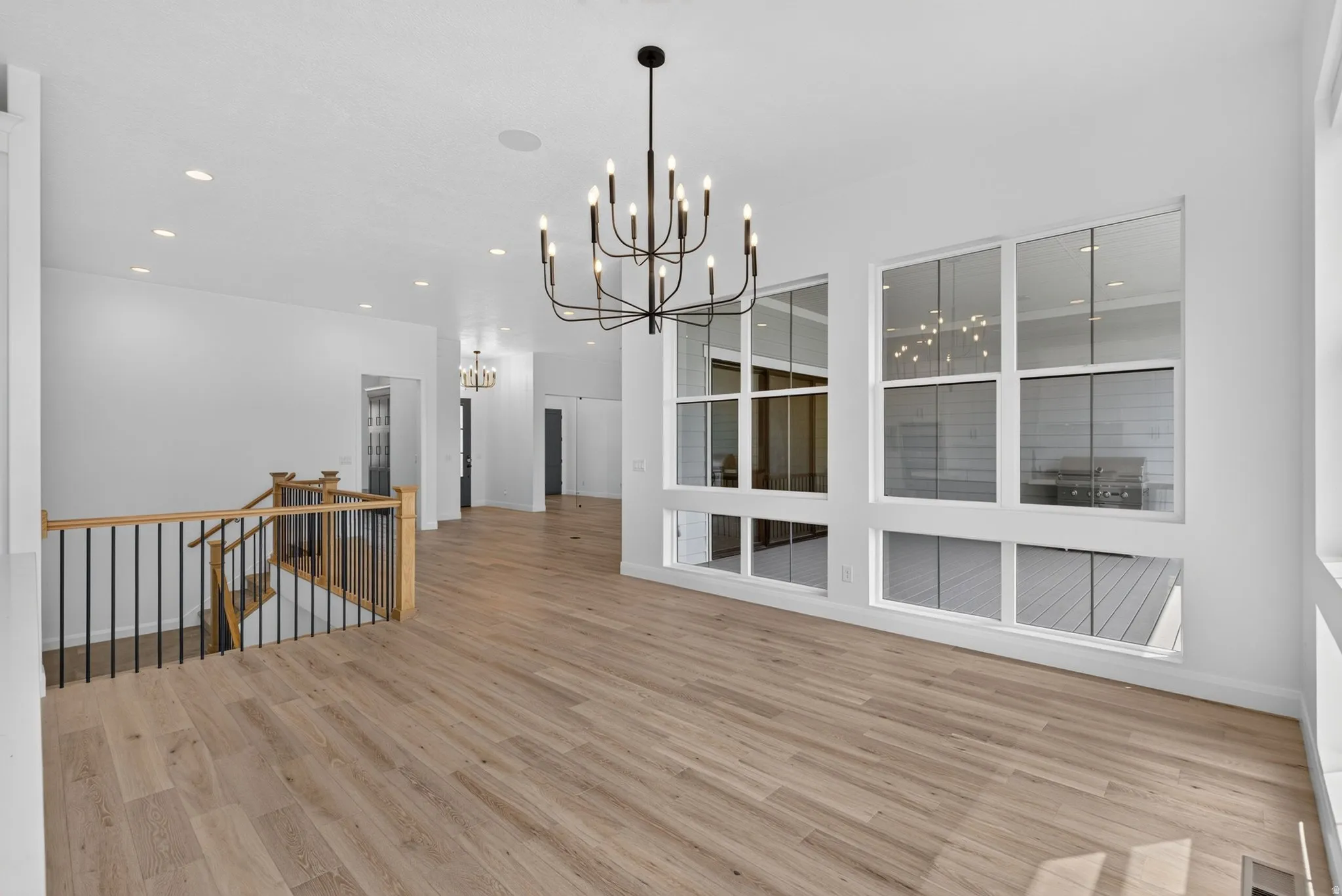 Spacious interior featuring wood-finish flooring and a contemporary black chandelier