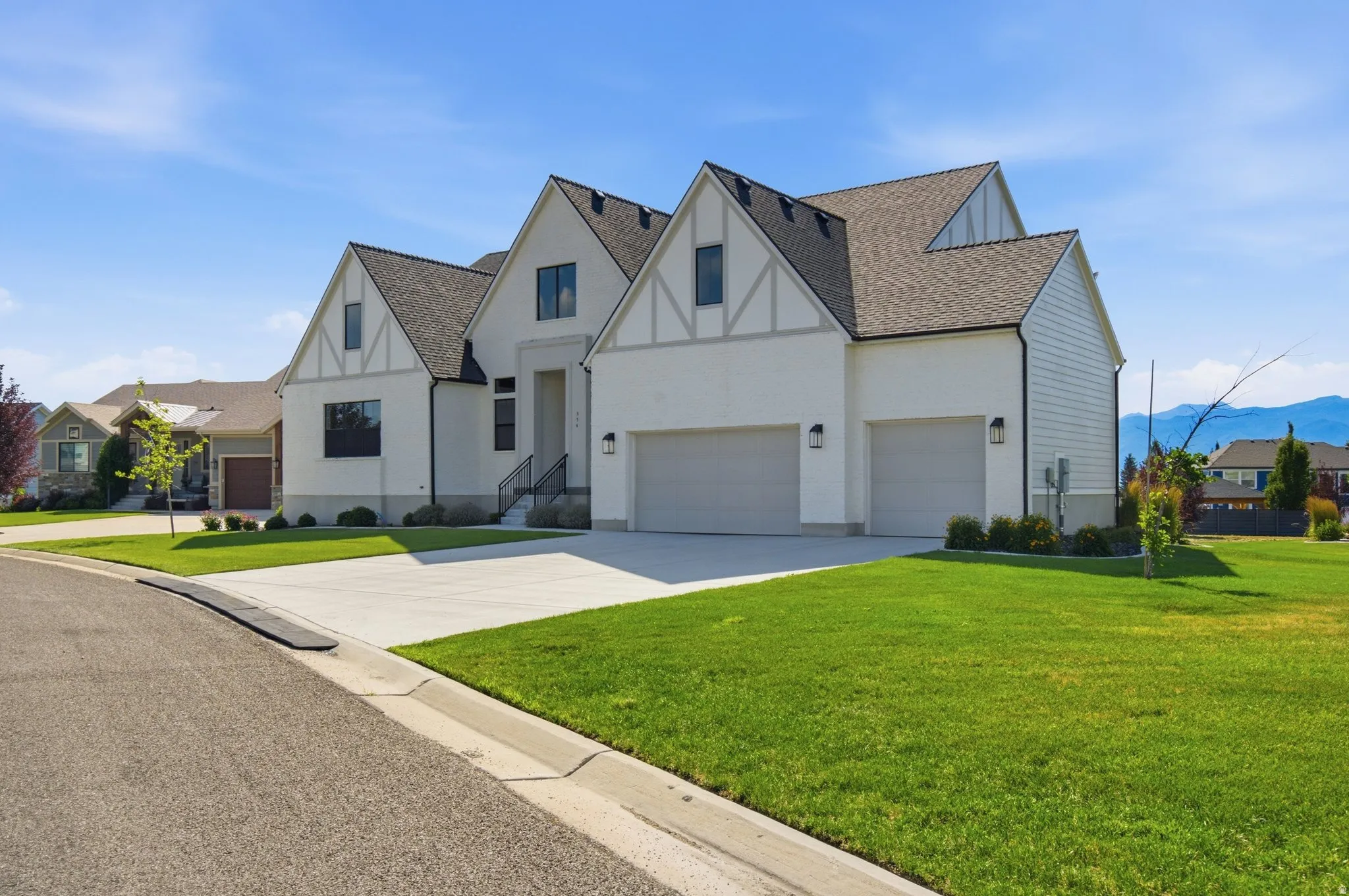 Contemporary residence featuring a two-car garage, white siding, and a dark shingle roof