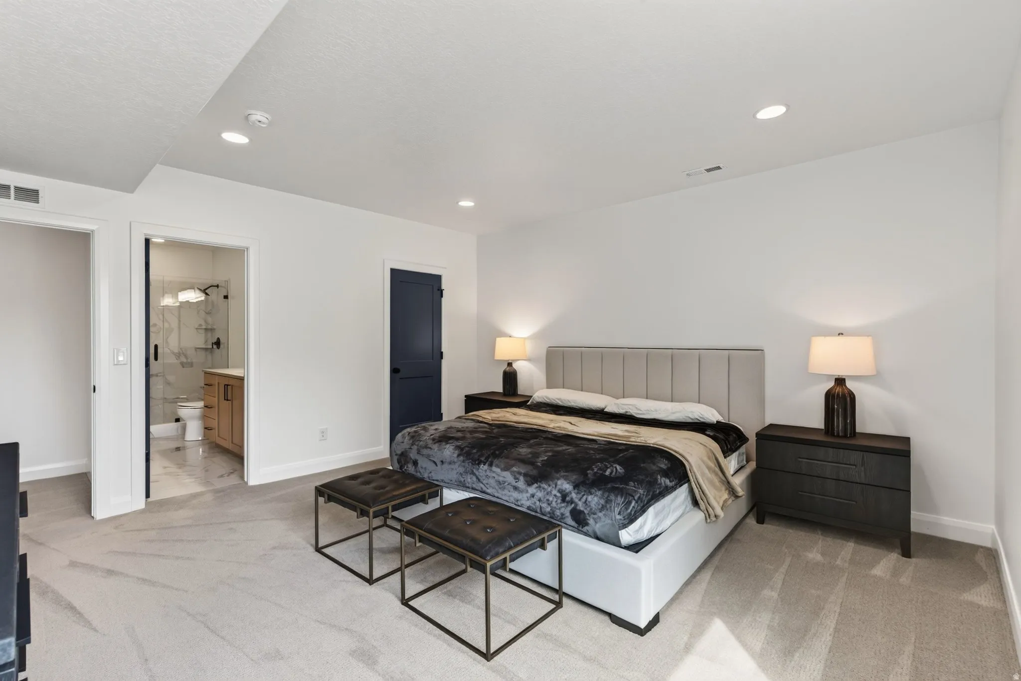 Carpeted room with recessed lighting and a dark blue interior door