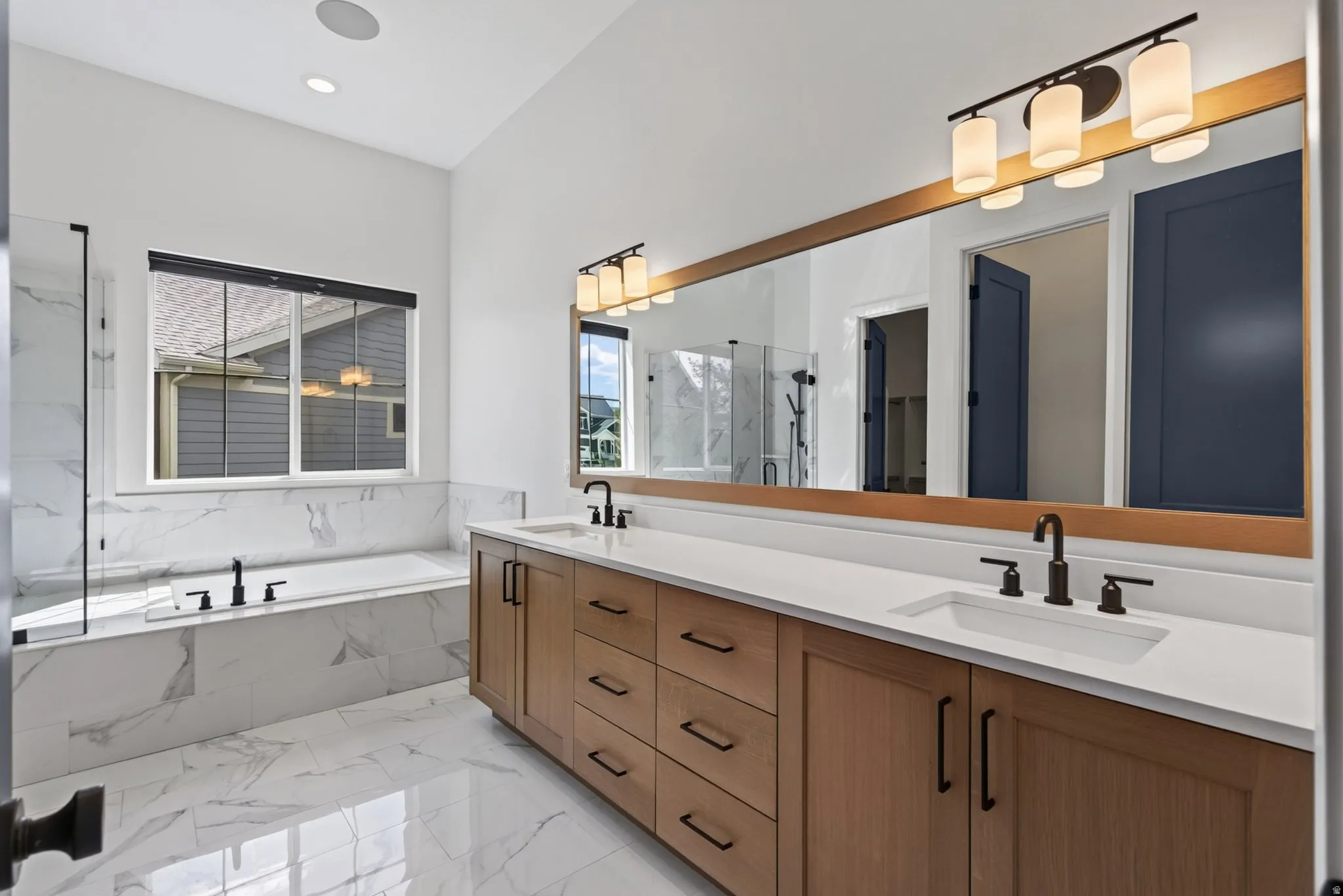 Dual wood-finish vanities with white countertops and undermount sinks