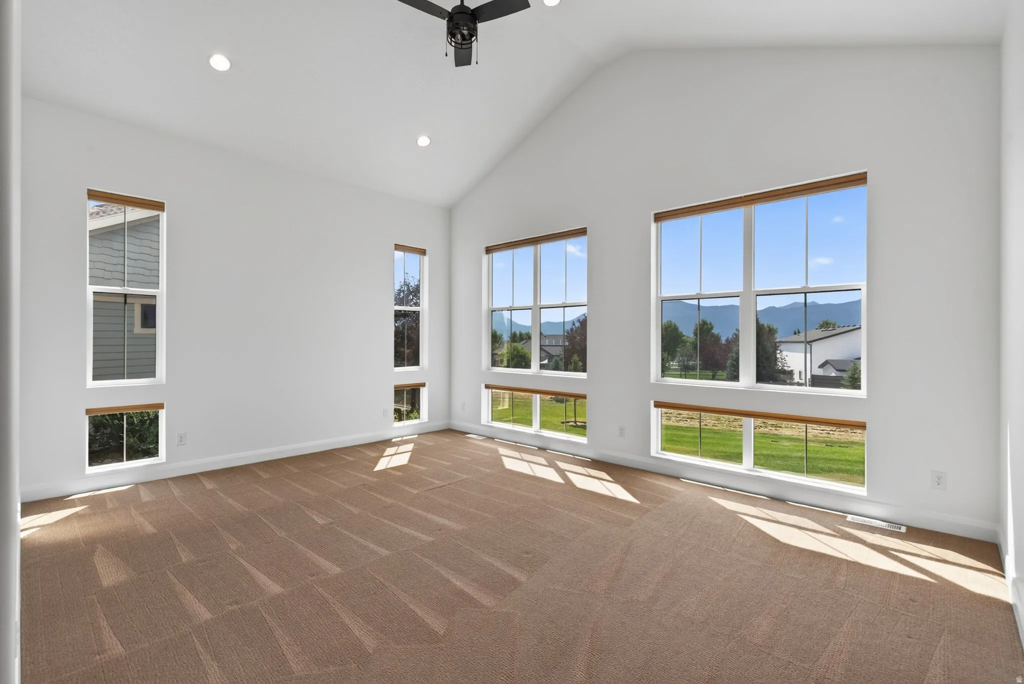 Spacious interior featuring a vaulted ceiling and recessed lighting