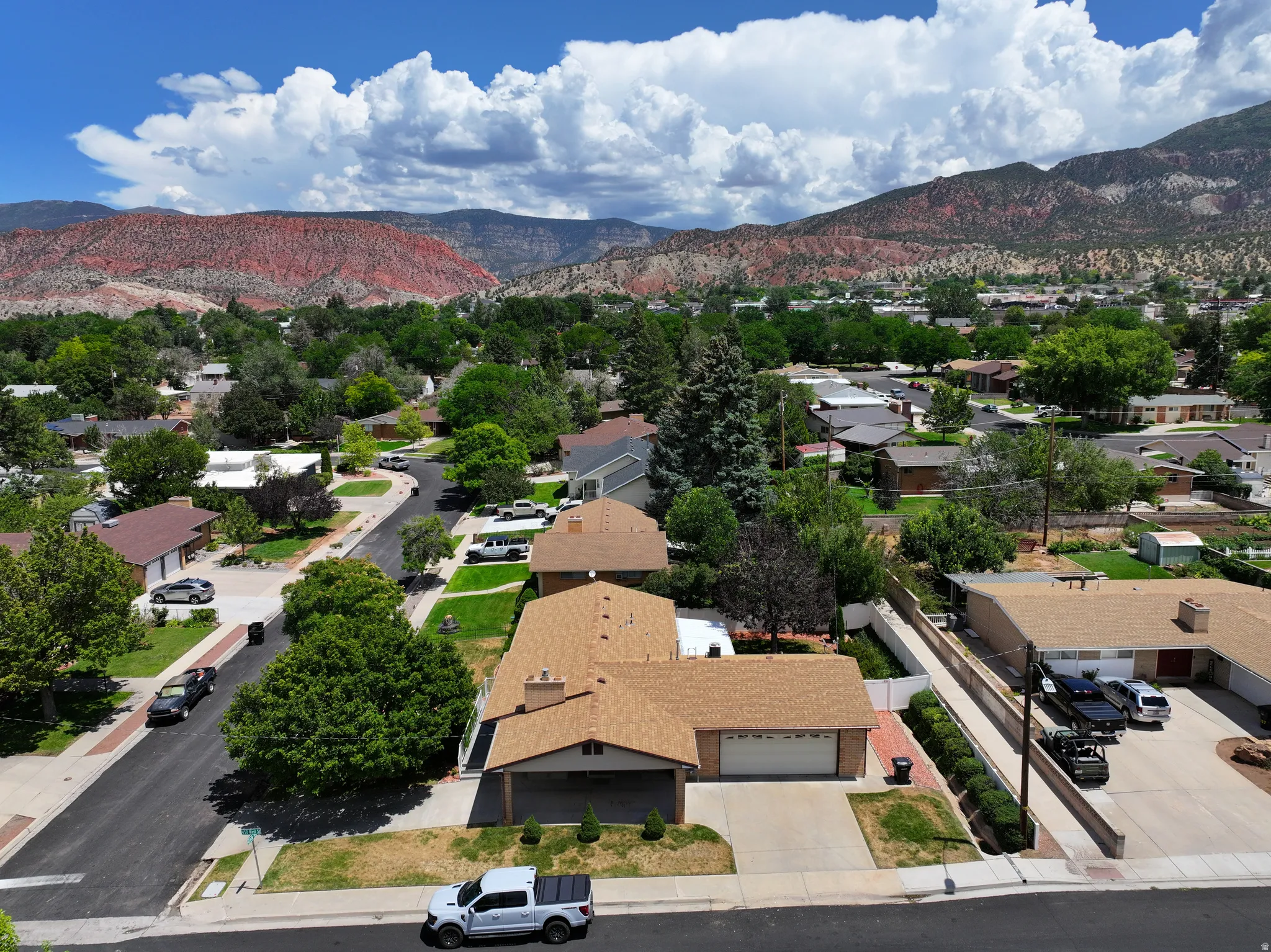 Aerial perspective showcasing a residential neighborhood with a prominent red rock mountain backdrop